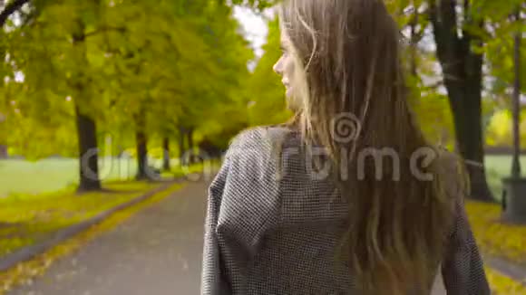 一个穿着格子夹克的白人女人微笑着走在路上年轻的黑发女孩漫步在视频的预览图