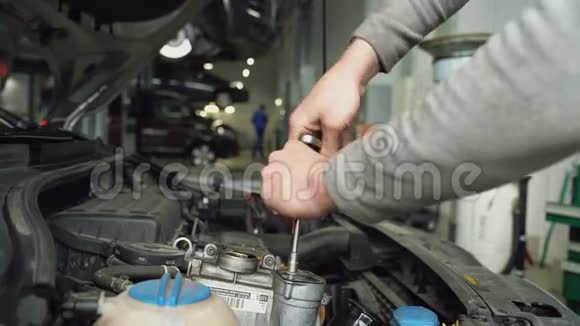 汽车机械师拧开机油填料的盖子视频的预览图