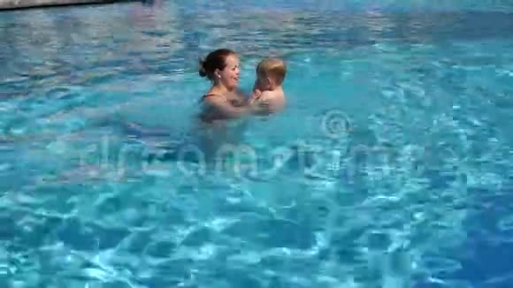 一位体贴的母亲教她的儿子潜入游泳池的水中视频的预览图