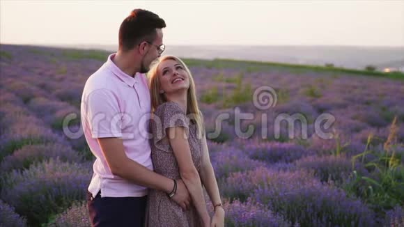 年轻人站在一片盛开的薰衣草地里拥抱他的女朋友视频的预览图