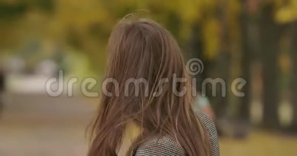 漂亮的高加索女人摇着她棕色的长发对着镜头微笑穿格子夹克的优雅女士视频的预览图