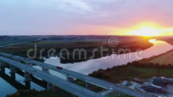 日落时公路桥上的汽车来往空中观景视频的预览图