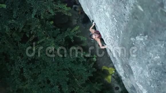 俯视女子攀岩者在艰难的运动路线上攀爬做一个艰难的动作和剪绳视频的预览图