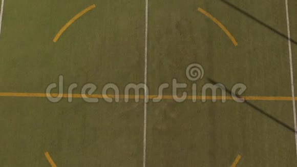 在一个五人制的足球场上一个女孩坐在一个巨大的阴影下球在她身边的鸟瞰图视频的预览图