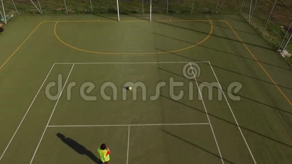 一个在五人制足球场进球的女孩的无人机鸟瞰图视频的预览图