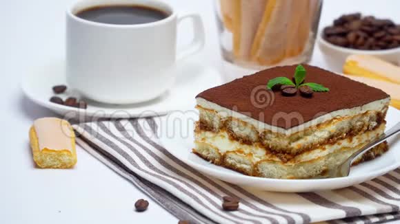 提拉米苏甜点广场部分萨沃亚迪饼干和一杯白色背景咖啡视频的预览图