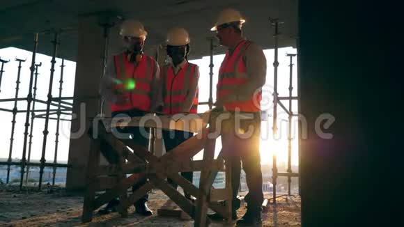 现代施工现场的施工工人微笑的工程师看着建筑工地上的蓝图视频的预览图