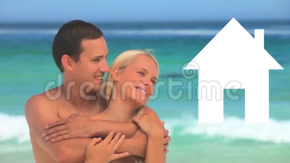 假日夫妇拥抱在海边而房子的图标充满了黄色视频的预览图