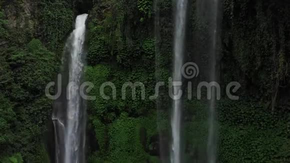 关闭绿色雨林中的瀑布在山地丛林中鸟瞰瀑布塞库普尔有人倒下了巴厘视频的预览图