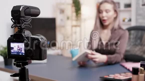 vlogger在她的创意工作室里用相机做书评视频的预览图