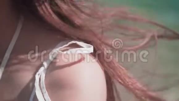 海滨女孩的肖像漂亮的女孩嘴唇涂着红色口红特写肩膀和头发视频的预览图