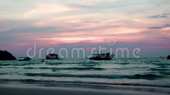 晚上的海浪水来了在汹涌的波涛中一个人皮划艇的轮廓船剧烈摇晃天空是淡红色的视频的预览图