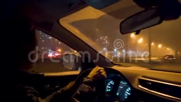 在夜城一个女人骑在汽车的车轮后面视频的预览图