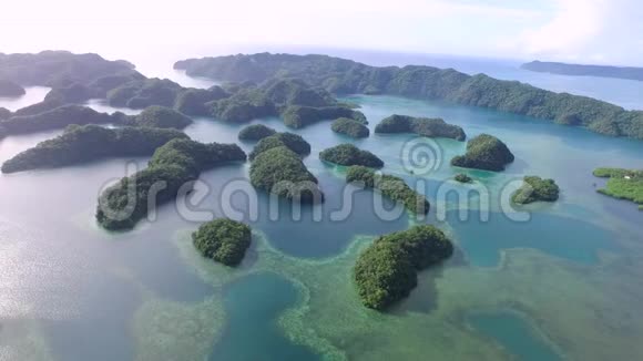 鸟瞰科罗岛许多绿岛带有五颜六色珊瑚礁和热带泻湖的海景空中景色视频的预览图