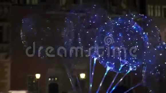 带彩色LED灯的气球在老旅游城市中心的夜街上出售视频的预览图