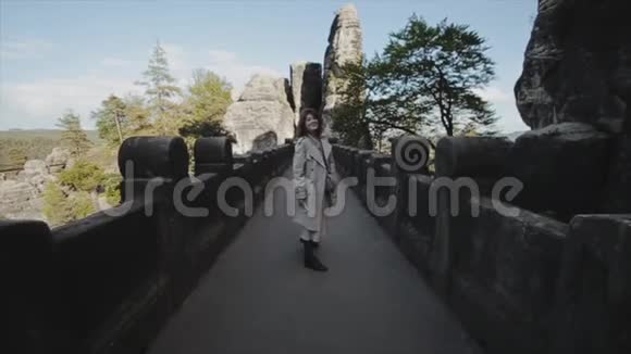 慢动作后景美丽的年轻女子走在山上的石头小径上巴斯蒂瑞士萨克森视频的预览图