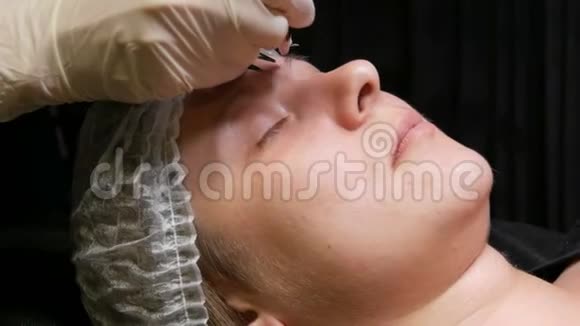 美容师他的手在病人的脸上用特殊的工具做了一个新形状的眉毛视频的预览图