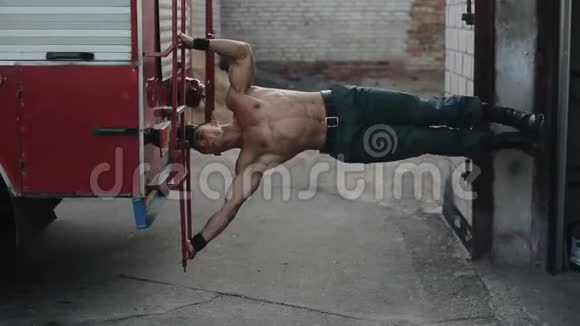 一个英俊强壮的运动员在外面的红条上用消防车工作视频的预览图