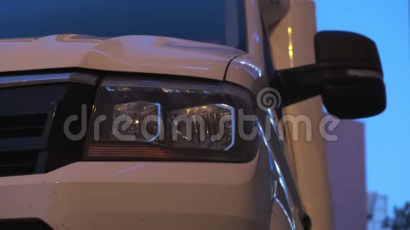 白色的商用卡车停在一个夜晚的城市街道上视频的预览图