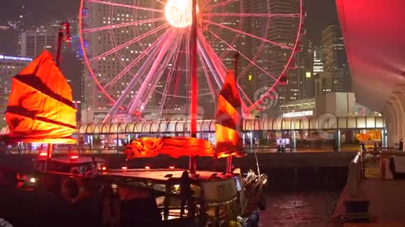 明亮的亮船与红帆对接摩天轮在夜间在大城市4k视频的预览图