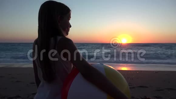 儿童在日落时玩沙滩球儿童在日落时看海浪女孩在日落时看风景视频的预览图