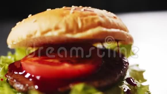 用肉饼和番茄做汉堡包在桌子上特写视频的预览图