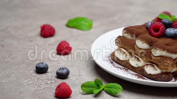 经典提拉米苏甜点与覆盆子和蓝莓在灰色混凝土背景下的部分视频的预览图