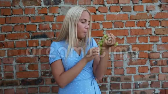 穿蓝色裙子的女孩吃葡萄视频的预览图