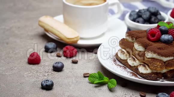 经典提拉米苏甜点与覆盆子蓝莓和咖啡在混凝土背景下的部分视频的预览图