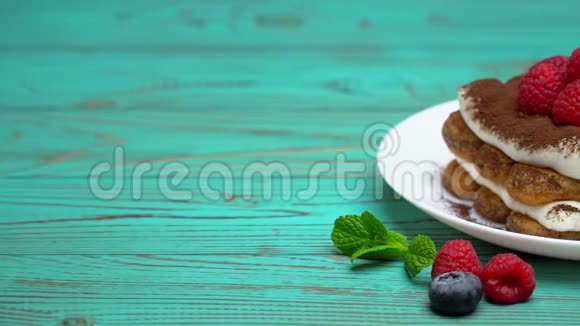 经典提拉米苏甜点与覆盆子和蓝莓在木制背景下的部分视频的预览图
