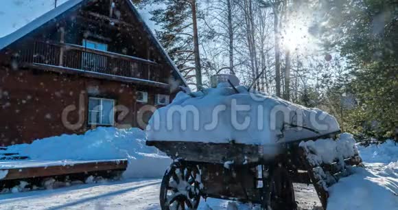 电影院森林里冬天阳光明媚的风景带着房子缓慢美丽的降雪视频循环视频的预览图