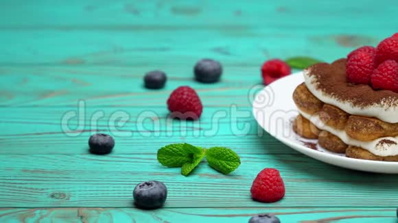 经典提拉米苏甜点与覆盆子和蓝莓在木制背景下的部分视频的预览图