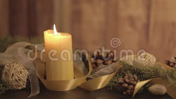 用点燃的蜡烛松枝天然的松果金色的缎子和白色的风琴点燃的火焰把圣诞节的环境关上视频的预览图
