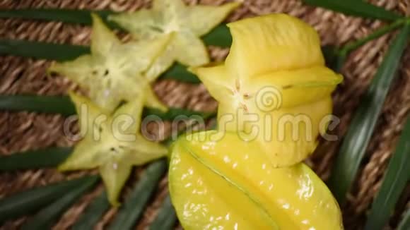 旋转背景上的黄色杨桃果上景异果热带棕榈枝素食和生食概念视频的预览图