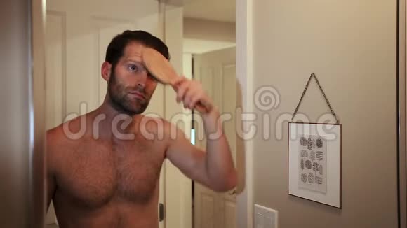 英俊的白种人年轻男子一边梳头一边看着浴室镜子里的自己HD24FPS视频的预览图