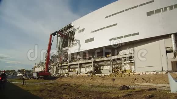 红色挖掘机拆除曲棍球球场的立面视频的预览图
