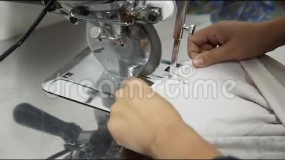 女人在工作场所的特写镜头上用自动刀切T恤视频的预览图