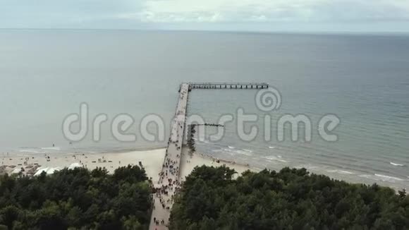帕兰加立陶宛2019年7月在帕兰加沙滩和海上的桥梁上行走的人的空中全景视频的预览图