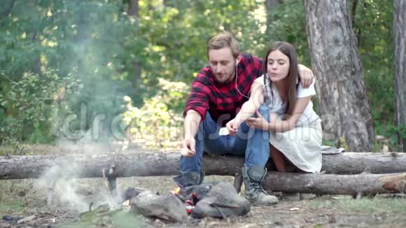 在森林里露营的情侣有徒步野餐背景的公司朋友们享受森林周末烧烤视频的预览图
