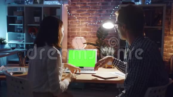 女孩和男孩讨论工作指向色度键模拟笔记本电脑屏幕视频的预览图