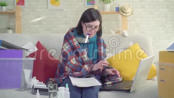 劳累和生病的女性工作狂在家工作带温度视频的预览图