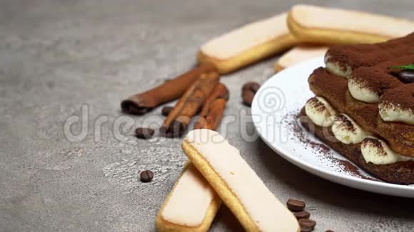 陶瓷盘子上的经典提拉米苏甜点和混凝土背景上的萨沃亚迪饼干视频的预览图