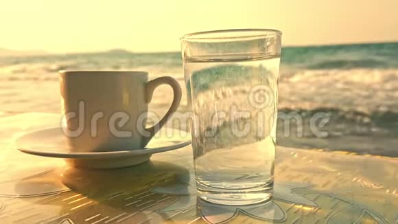 土耳其咖啡和一杯水在缓慢运动的海浪前视频的预览图