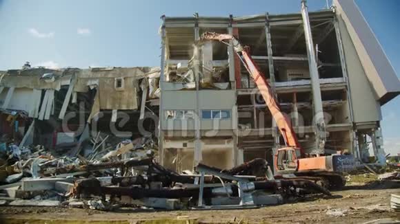 挖土机摧毁了废弃的曲棍球体育场的支撑物视频的预览图