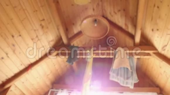早上好醒来时住在小屋的木制阁楼上衣服和毛巾挂在周围阳光透过窗户照射进来视频的预览图