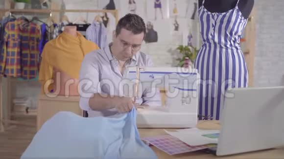 男士时装设计师在缝纫机上缝缝视频的预览图