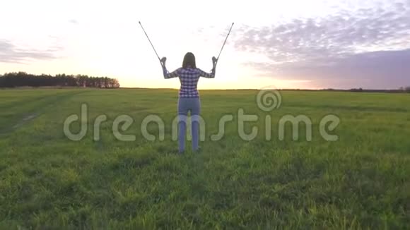 夕阳西下的田野里一个年轻的女人扔拐杖快乐地举起双手视频的预览图