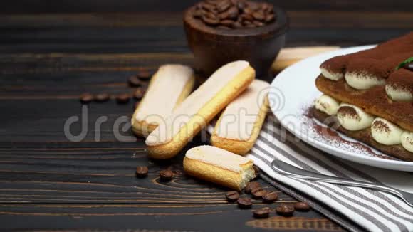 经典的提拉米苏甜点和萨沃亚迪饼干在陶瓷盘子木制背景视频的预览图