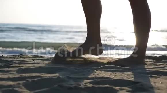 女人的腿在沙滩上与美丽的海景背景靠近女性的脚在海洋中漫步视频的预览图