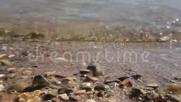许多美丽的石头被光波海水润湿太慢了视频的预览图